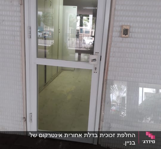 דלת זכוכית עם מסגרת לבנה ומנעול